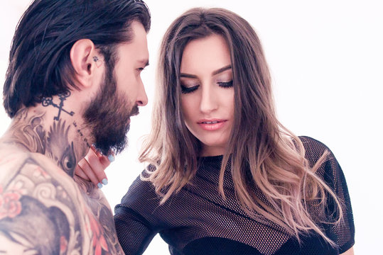 Sensual young woman touching a tattooed man