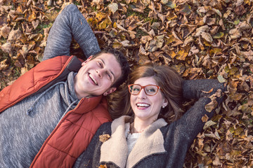 Woman and Man lying on Leaves in Autumn