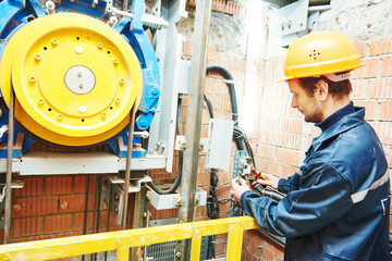 machinist worker adjusting elevator mechanism of lift