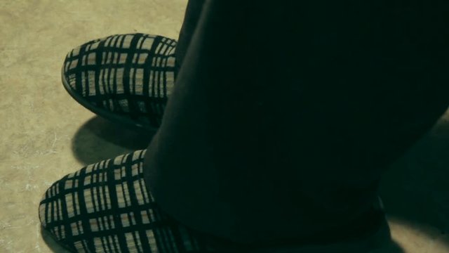 An elderly man in old slipers