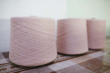 Bobbin of rose thread on table