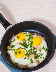 fried eggs with bacon in a frying pan