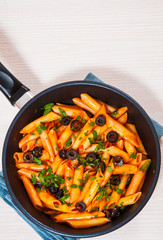 Penne pasta with tomato sauce in a frying pan