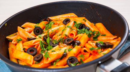Penne pasta with tomato sauce in a frying pan