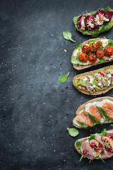 Different kinds of colorful sandwiches on black