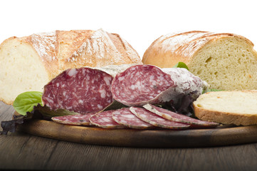 wooden cutting board with salami and bread