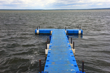 pontoon floating dock from blue plastic pontoons on a lake with