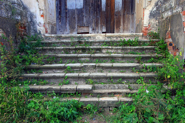 old medieval dilapidated porch with old stone steps covered with