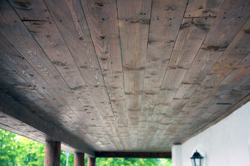 the ceiling is lined with wooden planks in porch of building