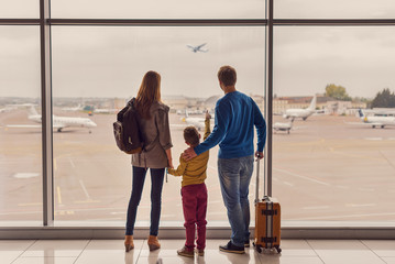 Family looking out window at airport