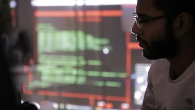 Arabic IT specialist working on computer at night. Hacker breaking computer code. HD.