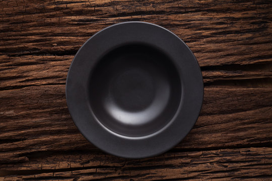 black empty bowl on wooden table background