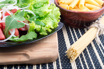 Composition on the table with a fresh salad of tomatoes, onions,