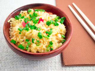 Wooden bowl of cooked rice and leek
