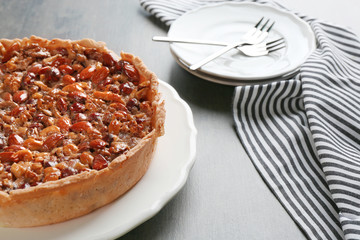 Delicious cake with nuts on table