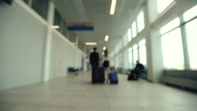 Couple with luggage meets, and walking in the airport. blur of movement people walking at the airport