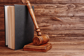 Judge's gavel and book on wooden wall background