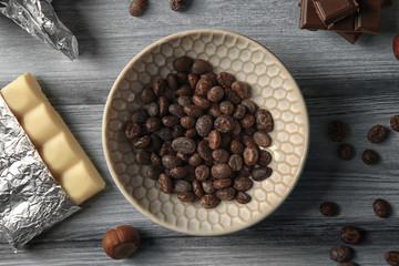 Chocolate and nuts on a gray wooden background, top view
