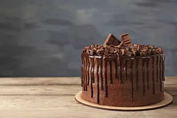 Rolgordijnen Tasty chocolate cake on grey wall background © Africa Studio
