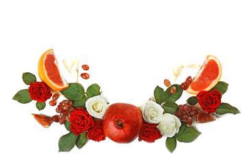 Red pomegranate and floral arrangement on white background