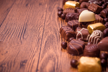 Assorted chocolates on wooden background