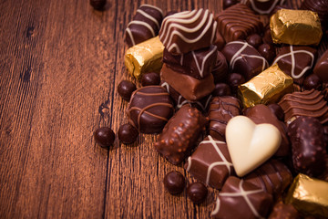 Assorted chocolates on wooden background