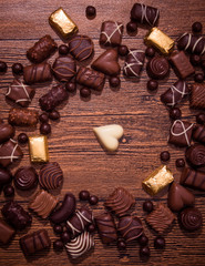 Assorted chocolates on wooden background