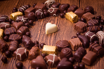 Assorted chocolates on wooden background