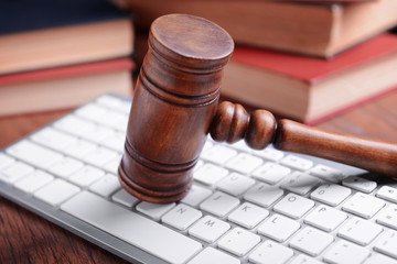 Wooden gavel and keyboard on desk