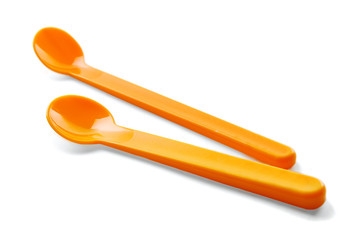 Bright plastic spoons for child on white background