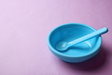 Bright baby tableware on color background