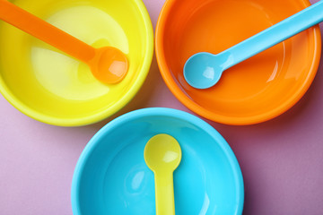 Bright baby tableware on color background, closeup