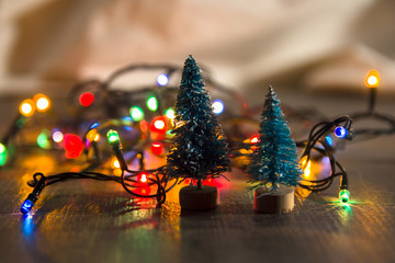 two Christmas trees on the background of bright Christmas gifts, bright colored lights, place under the text as substrate