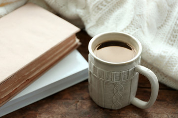 Hot drink with books and plaid on windowsill