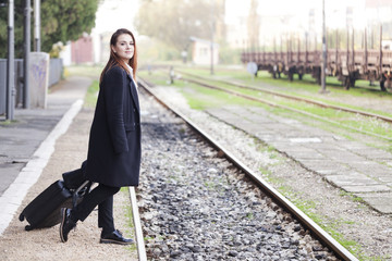 Obraz premium Teenager waiting for a train at the station