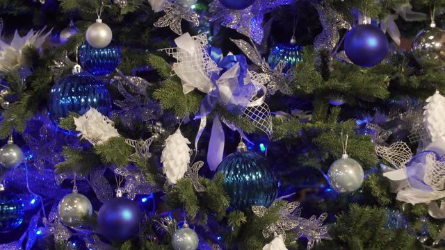 Christmas tree decorated with bright blue garlands and toys. the fir-tree decorated with blue toys. A big beautiful fir-tree with New Year's toys