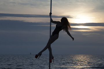 Beautiful silhouette girl on high heels pole dance