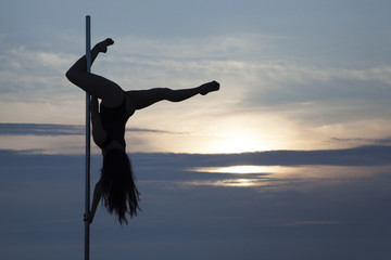 Element pole dance girl silhouette at sunset