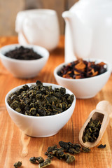 Fototapeta na wymiar Oolong green tea in white ceramic bowl on a wooden table. Selective focus.