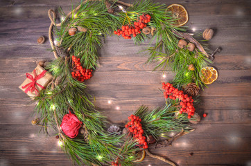 Fototapeta na wymiar New Year Decoration with Wreath of Pine Branches and Rowan