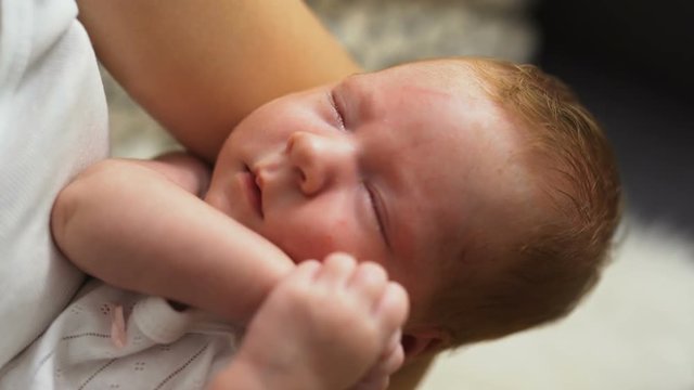 newborn baby sleeping in his mother's arms