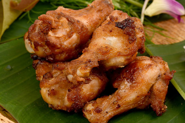Fried chicken on a background of green banana leaves.
