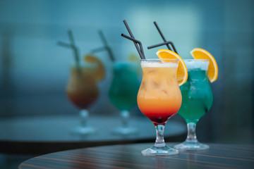 blue and orange summer cocktails with straw;