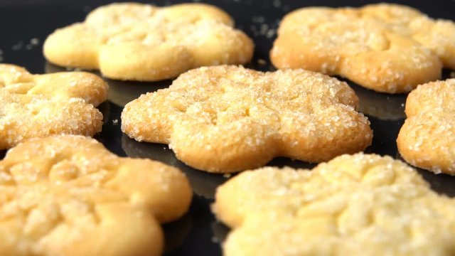 Delicious yummy freshly baked homemade cookies on a black roasting pan. Strewed with white sugar. Seamless loopable.