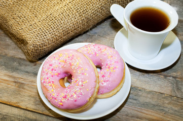 Sweet donut with pink frosting and sprinkles