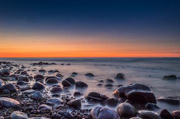 Obraz premium Sunset over the sea. Stone on the foreground.