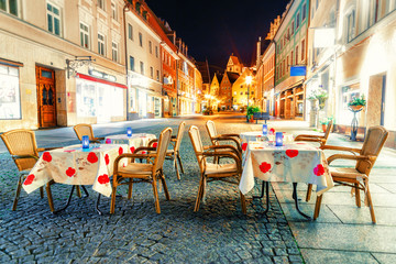 Citylights and street cafe in Fussen. Bavaria region, Germany. Evening scene.