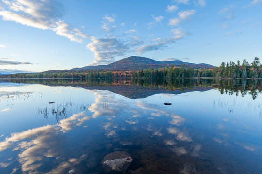 Blue Mountain with autumn colors and clouds reflecting in Lake Durant, Adirondacks