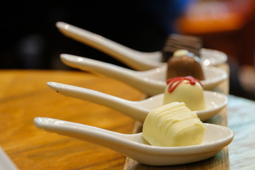 Fototapeta na wymiar Chocolate in white spoons for testing wine