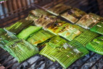 Grilled stuffed Glutinous rice wrapped in banana leaves on stove